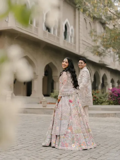 A "follow me to" style shot with a joyful look back. This image, set against the beautiful architecture of Fairmont Jaipur, is perfect for a save-the-date announcement.