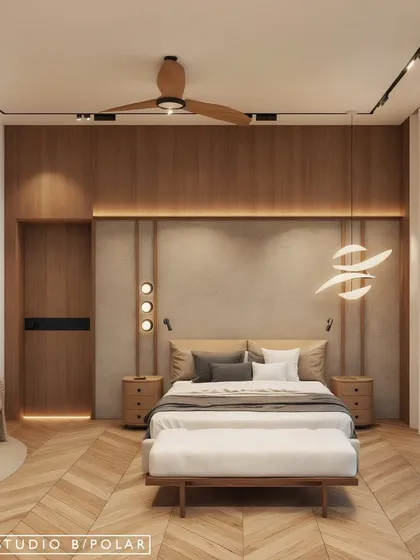 This bedroom design combines a wood-paneled feature wall with a textured headboard and sculptural lighting. The herringbone wood flooring adds another layer of pattern and warmth to the space.
