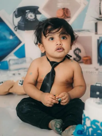 Taking a break from the cake to survey his empire. This shot captures the fun and chaos of a first birthday cake smash.