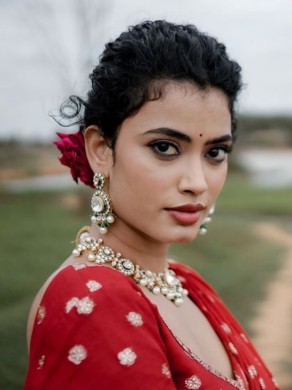 A beautiful portrait with a single red rose in her hair, adding a touch of romance.