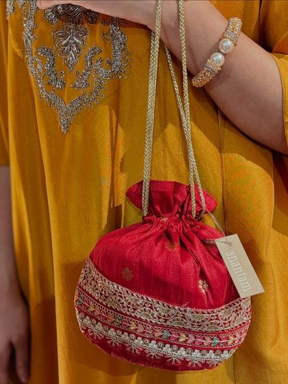 This red potli with its silver embroidery and drawstring closure is a timeless accessory for any Indian traditional outfit.