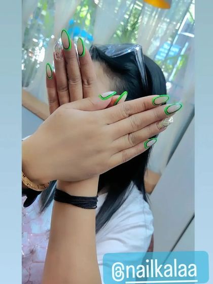 A neon green outline French manicure on almond-shaped nails. This design uses negative space to create a trendy and eye-catching look.