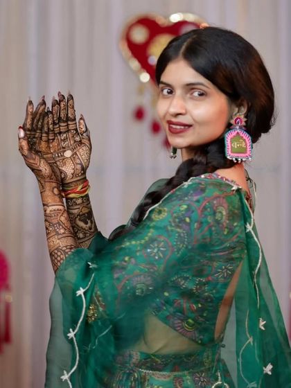 A happy bride showing her palms, covered in our intricate traditional mehandi. Her smile is our biggest compliment.