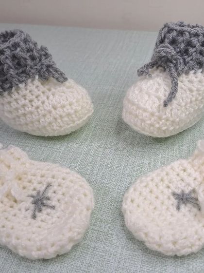 This simple and classic set for a baby boy includes two-tone grey and white booties and a matching pair of scratch mittens.