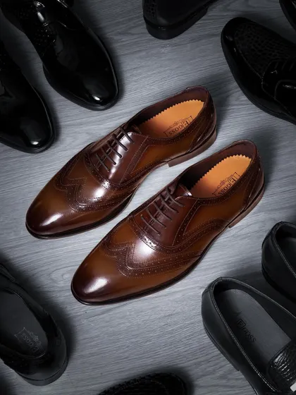 Capturing the essence of luxury. For these premium leather brogues, I used specific lighting techniques to highlight the rich texture of the leather and the fine details of the craftsmanship, creating a classic, high-end commercial photograph.