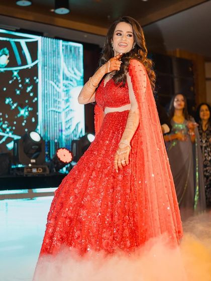 The perfect shot of a bride owning the stage. The combination of a stunning red lehenga, dramatic smoke, and confident moves makes for an unforgettable solo.