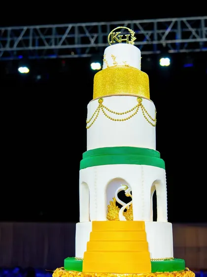 The royal engagement cake stands majestically against the night sky, ready for a grand celebration. The multiple tiers and intricate details are designed to impress.