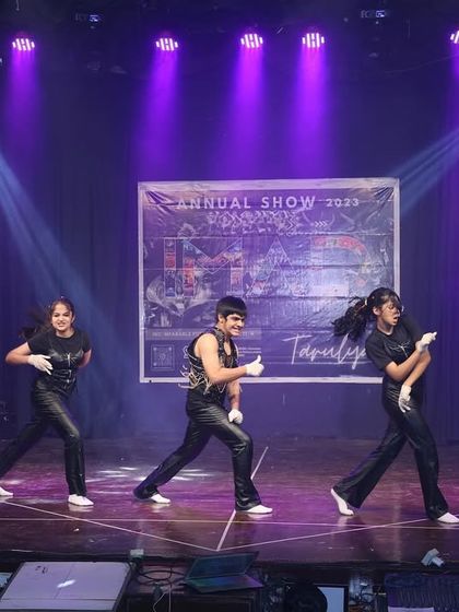 The group moves in unison, showcasing their sharp choreography and stage presence.