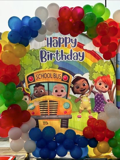 A closer view of the Cocomelon party setup, showing the school bus backdrop and colorful balloon arrangement.