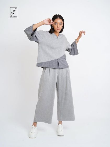 A grey color-blocked lounge set, posed to show the relaxed fit and unique design.