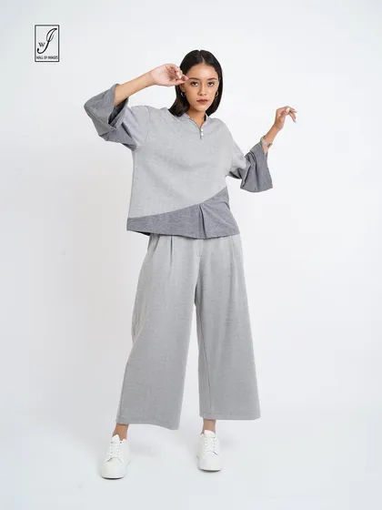 A grey color-blocked lounge set, posed to show the relaxed fit and unique design.