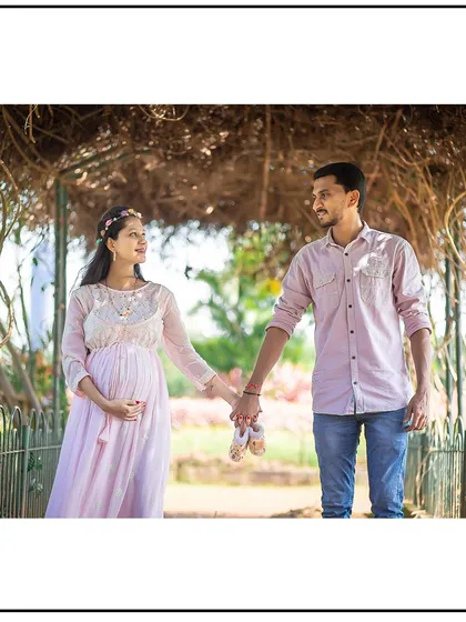 Holding hands while carrying a pair of baby shoes, this shot symbolizes jejich journey into parenthood together.