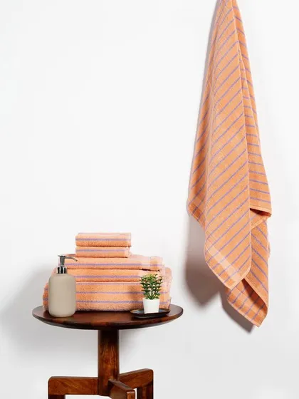 The peach-colored towel set, styled with the same simple elegance. This approach is effective for e-commerce, providing clear and attractive images of all available product variations.