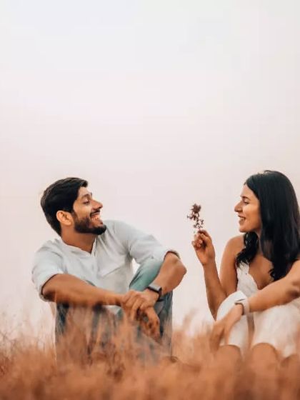A sweet, candid moment where the woman offers the man a flower, both sharing a genuine smile. We focus on capturing the small gestures that define your relationship.