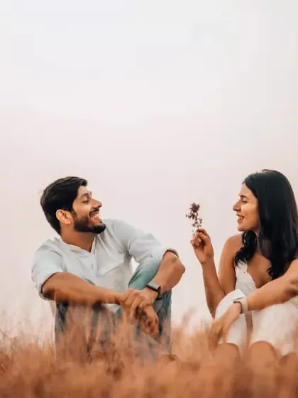 A sweet, candid moment where the woman offers the man a flower, both sharing a genuine smile. We focus on capturing the small gestures that define your relationship.