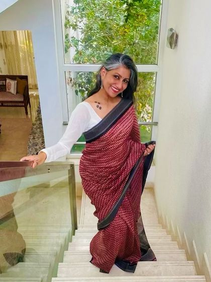 A full-length view of the red printed saree, showing how beautifully it drapes. I paired it with a simple white long-sleeved blouse for a clean, modern contrast.