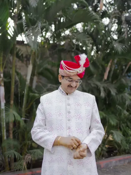 The groom checks his cuffs, another stylish getting-ready shot that captures the small details of his attire.