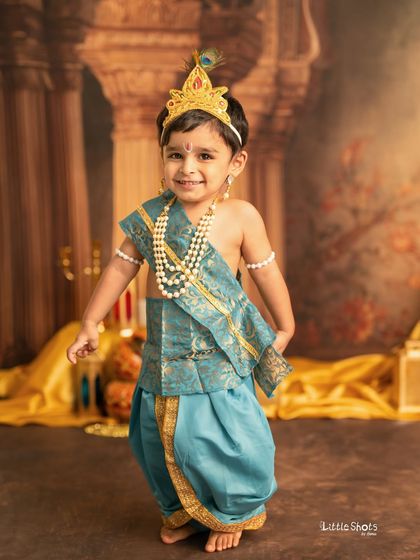 This little boy is all smiles, dressed as Krishna for his festive photoshoot. His happy energy is contagious in this wonderful traditional portrait.