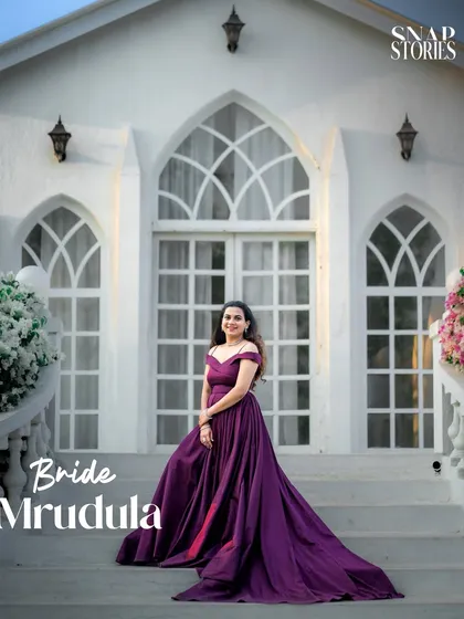 A beautiful solo portrait of the bride on the steps of a white chapel-like building, showcasing her elegant gown and serene expression.