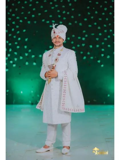 A full-length portrait of the groom, looking elegant and ready for his wedding.