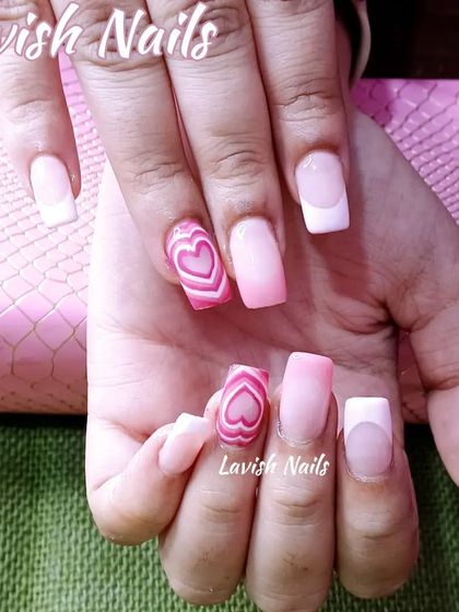A fun and playful Valentine's Day theme with pink nails, a French tip, and a striped heart design.