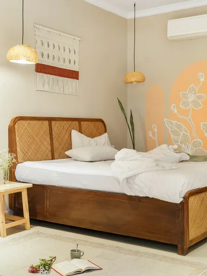 In our Goan project, Unallome, we embraced the philosophy of "susegad" or slow living. This bedroom is a testament to that, using a simple palette of natural materials like cane and wood, complemented by a hand-painted mural. It is a serene retreat designed for rest and connection.