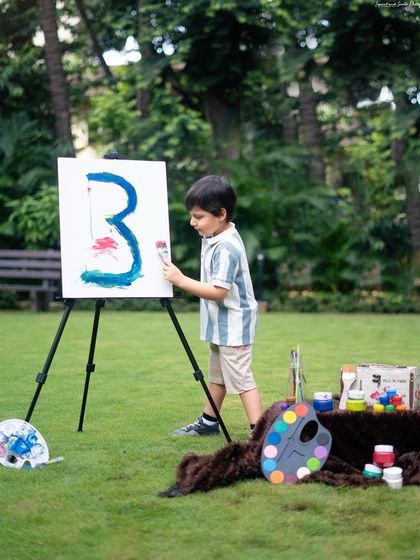 A candid moment of the little artist at work, adding the finishing touches to his painting during his outdoor birthday session.
