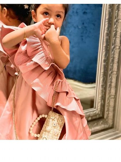 A candid moment with a little fashionista in our "Blush Desire" dress. It’s designed to be as comfortable as it is beautiful, allowing for playful moments and happy memories.