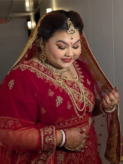 A candid moment capturing Shreyoshi's bridal glow. The soft lighting shows off the flawless finish of her skin and the richness of the eyeshadow colors.