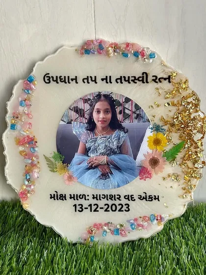 A close-up of the frame for a young girl's religious milestone, showing the colorful crystal border and gold foil details.