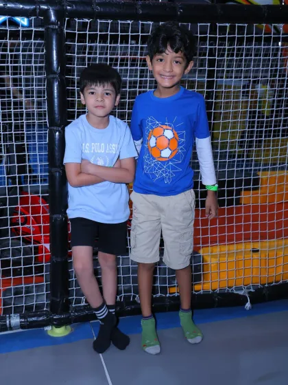 Two friends stand together in the play area, ready for more fun. It's a great place for kids to socialize and play.