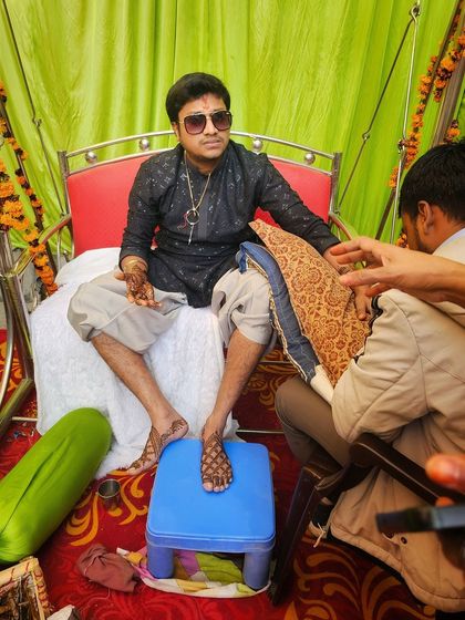 The mehndi ceremony in full swing. Here I am applying a traditional design to the groom's foot, ensuring every part of his wedding look is perfect.