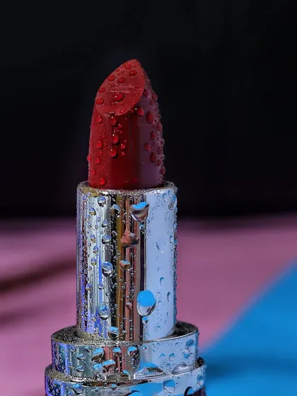 An extreme close-up of a Mamaearth lipstick, where water droplets mimic condensation, suggesting a fresh and hydrating formula.
