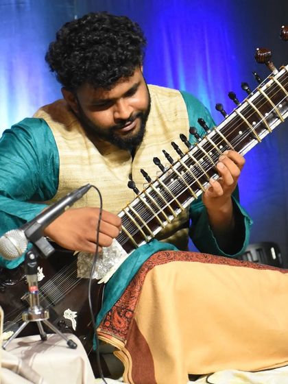 A close up of my playing technique during a concert. You can see the mizrab, or plectrum, on my index finger, which is used to strike the strings.