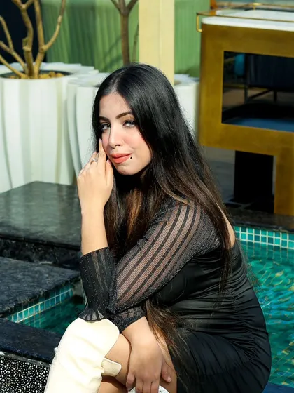 A seated portrait from the same influencer shoot. The poolside setting adds a touch of glamour and lifestyle context to the image.