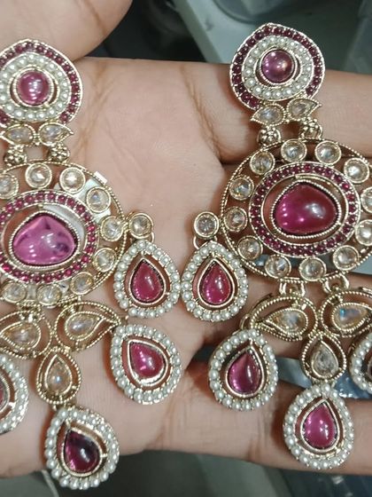A pair of chandbali-style earrings with beautiful pink stones and pearl borders.