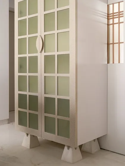 This full-height crockery almirah was designed for our Gingham Dreams project. The gridded glass doors and clean lines are inspired by Japanese design, and the entire unit is elevated on stone blocks, giving it a light, floating quality.