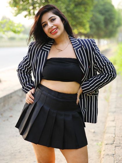 A full-look shot that displays the entire outfit, including the pleated skirt and bandeau top.