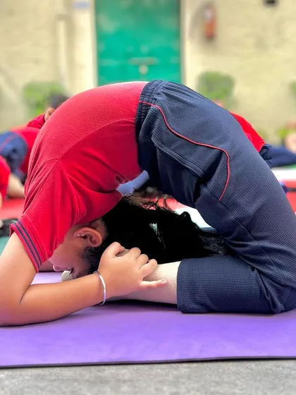 This young student demonstrates a deep reclining hero pose, a great stretch for the quadriceps and spine.