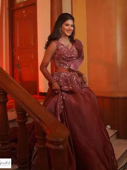 A full-length shot of the bride on a staircase, showing off her gorgeous mauve gown.
