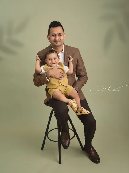 A proud father with his little boy. This classic father-child portrait captures a quiet moment of connection, showcasing their bond in a timeless studio setting.