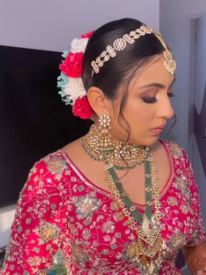 A side view of the bride, showing the colorful floral arrangement in her bun.