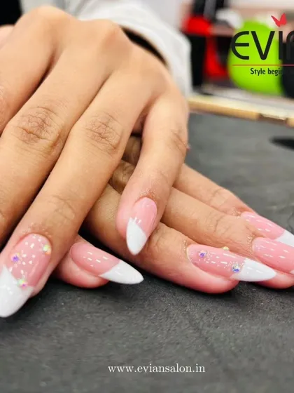 You can never go wrong with a classic French manicure. Here, I've given it a modern twist with a soft pink base, crisp white tips on almond-shaped extensions, and a few carefully placed rhinestones for a touch of sparkle.