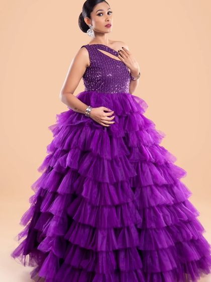 Another look at the stunning purple ruffled gown, showcasing its structure and the way the light catches the sequined top.