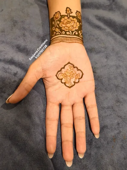 A minimal yet striking design with a single floral motif on the palm and a matching wrist cuff.