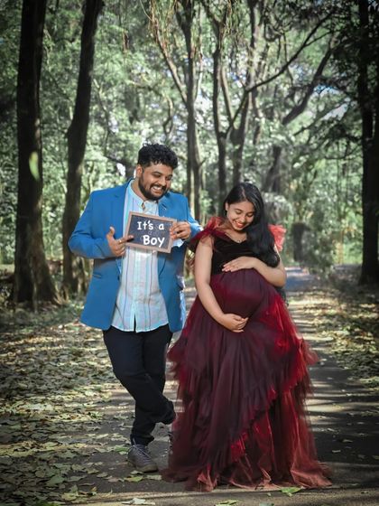 A fun "It's a Boy" announcement during a maternity shoot. The dark ruffled gown provides a beautiful contrast to the happy news, making it a memorable photo for the family.