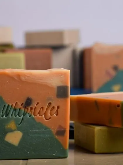 A collection of our colorful summer soaps, with the Watermelon Limeade bar front and center.