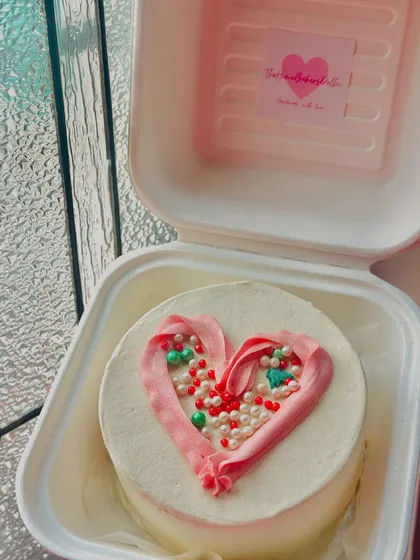 A Christmas-themed bento cake with a heart made of festive sprinkles. A small and sweet way to share some holiday cheer.