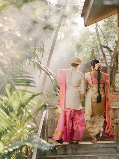 A couple walks up a staircase, with the morning sun filtering through the trees, creating a magical, ethereal glow.