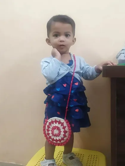 A sweet pose from my daughter with her little crochet bag. It's the perfect size for a toddler to carry her little treasures.